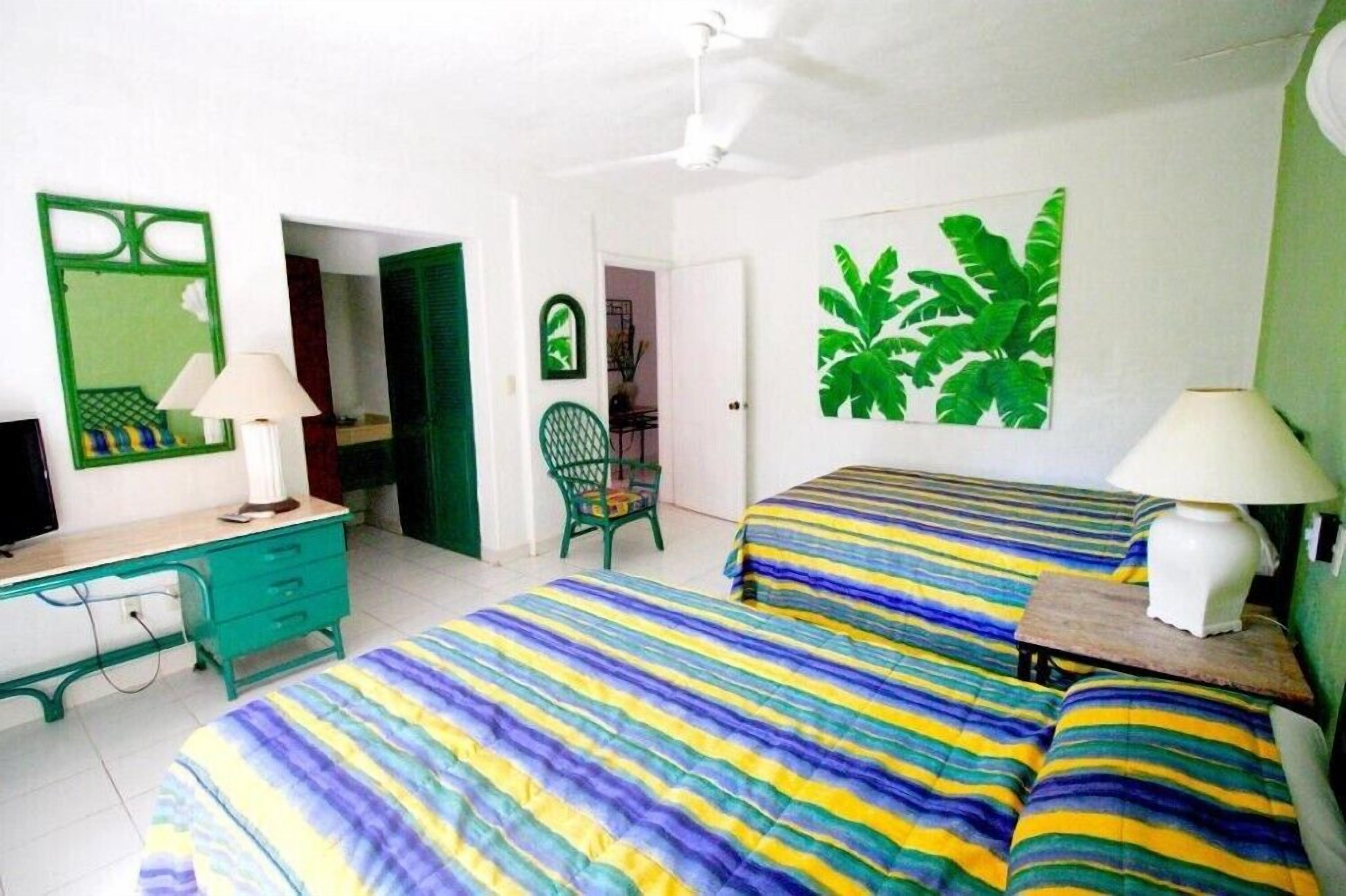 Une chambre avec deux lits, un bureau et une chaise.