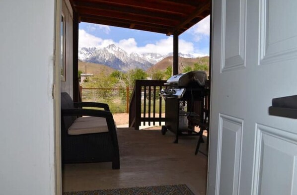 Enjoy al fresco dining with a mountain view from this outdoor space, featuring a grill and comfortable seating.