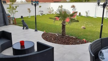 Relax in a peaceful outdoor space with comfortable seating and lush greenery.