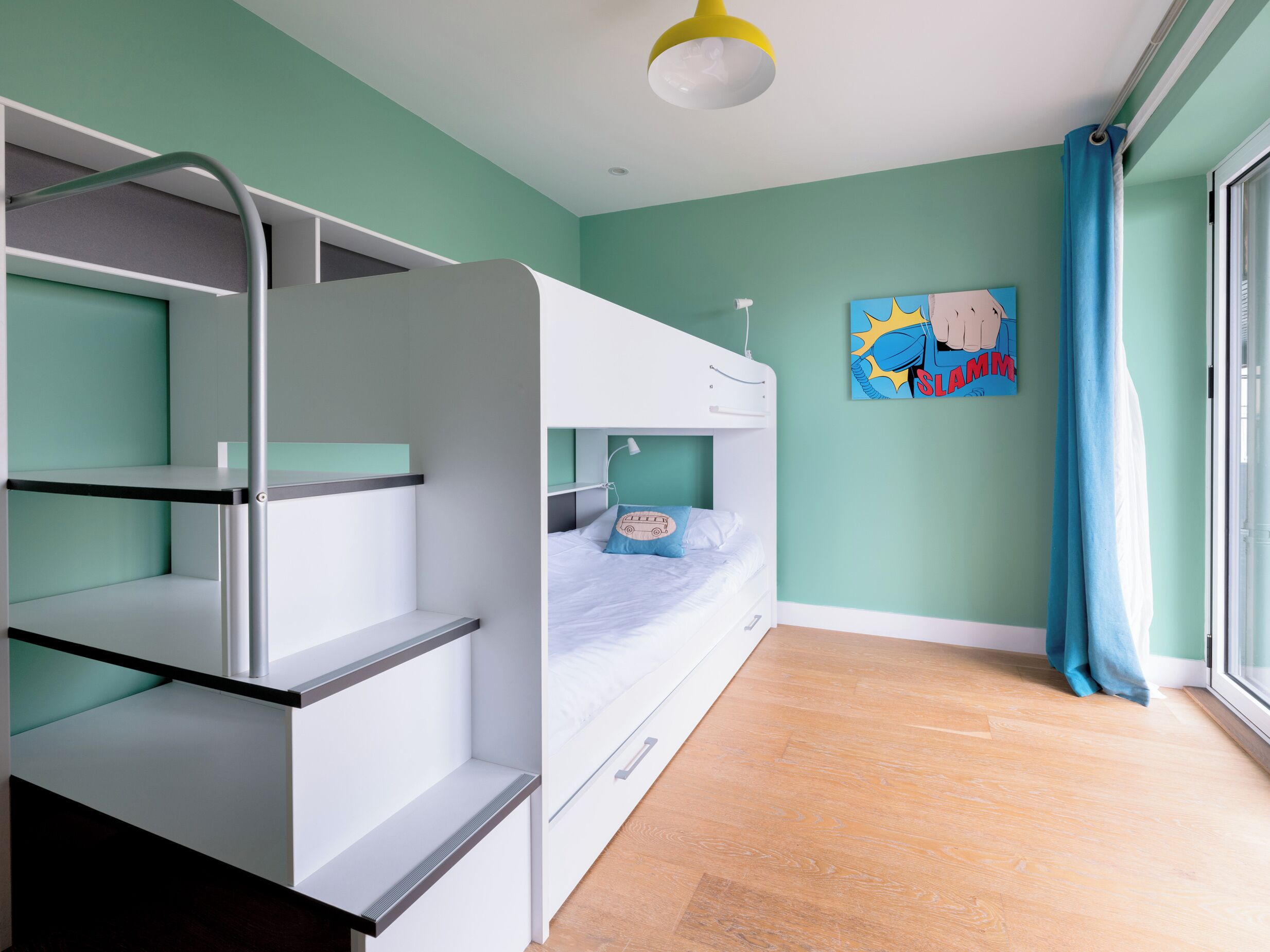 Habitación con literas, una ventana, un cuadro en la pared y una cortina.