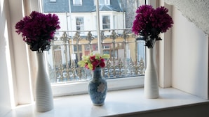 Two white vases with purple flowers on a windowsill. - 7 Bedroom Townhouse (Edinburgh)
