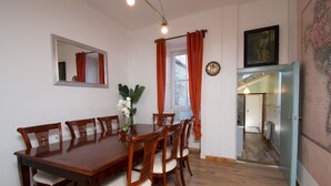 A dining area with a wooden table and chairs, a mirror on the wall, and a map on the wall. - 7 Bedroom Townhouse (Edinburgh)
