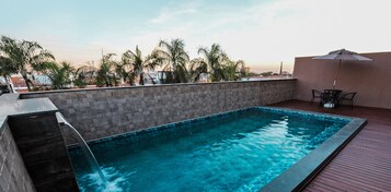 Una piscina al aire libre, tumbonas
