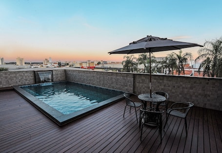 Una piscina al aire libre, sillones reclinables de piscina