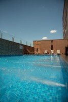Una piscina al aire libre, tumbonas