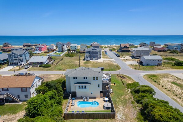 A residential area with houses, a swimming pool, and a view of the ocean. - The Dancing Sea Horse: Private Pool, Elevator, Spa (Kitty Hawk)