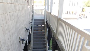 Eine Treppe mit weißen Geländern und einem überdachten Bereich mit Blick auf die Straße.