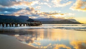 Un muelle de madera que se adentra en aguas tranquilas, con una estructura cubierta al final.