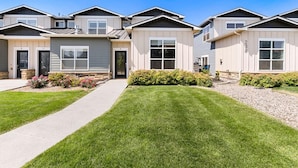 A row of modern, two-story houses with a uniform design, featuring large windows and a well-maintained lawn. - Gorgeous Townhome steps from the Brewery District! (Fort Collins)