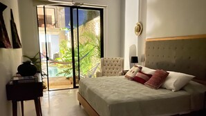 Un dormitorio con cama, mesita de noche, lámpara y vistas a una piscina a través de un ventanal.