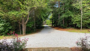 A gravel path leading through a wooded area with a stone bridge. - Quaint Little Cabin with a view. (Abbeville)
