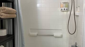 Een bad/douchecombinatie, een haardroger, handdoeken, shampoo