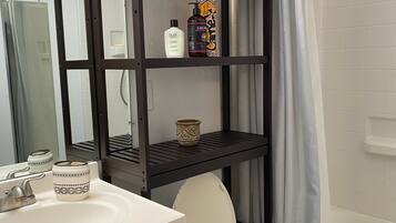 Een bad/douchecombinatie, een haardroger, handdoeken, shampoo