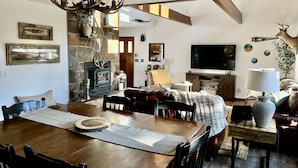 Un salon chaleureux avec une cheminée, une table à manger et un téléviseur.