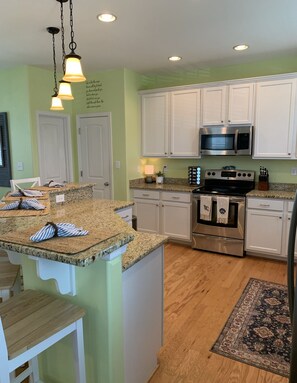 Enjoy cooking in this well-equipped kitchen with a central island, white cabinetry, and stainless steel appliances.