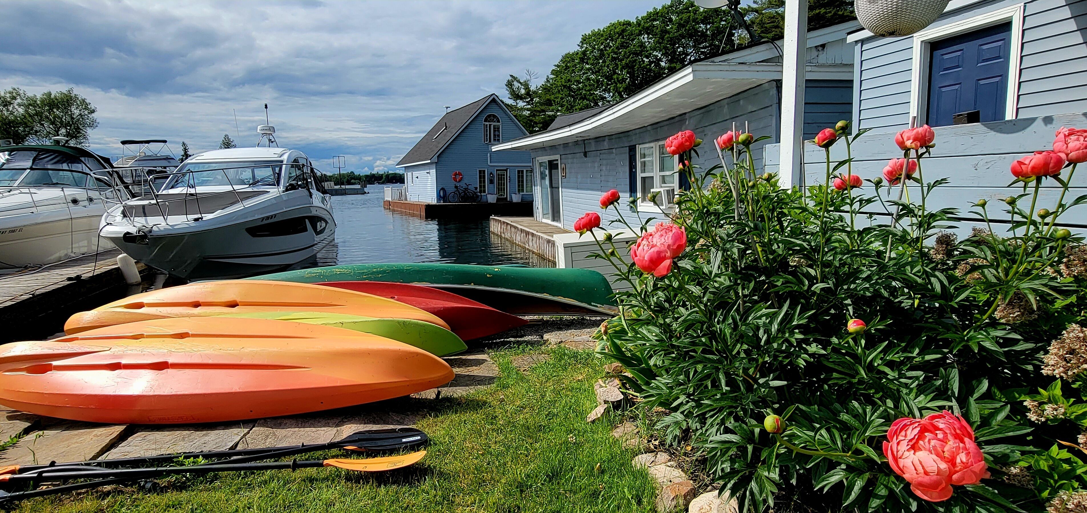 A dock with kayaks and a house with a blue door.