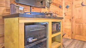 Eine Küche mit integriertem Mikrowellenherd, einem Edelstahlbackofen und einer Holzarbeitsplatte.