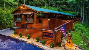 Una cabaña de madera con techo verde, un letrero y una pequeña bandera estadounidense.