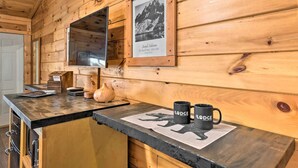 A wooden cabin interior with a wooden counter, framed picture, and two mugs on a coaster. - The Lodge Nantahala River<br>Bryson city, Nc. Suite #2<br>The Nantahala , Bryson city (Bryson City)