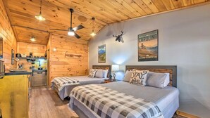A cozy cabin-style room with two beds, wooden walls, a kitchen area, and a ceiling fan. - The Lodge Nantahala River<br>Bryson city, Nc. Suite #2<br>The Nantahala , Bryson city (Bryson City)