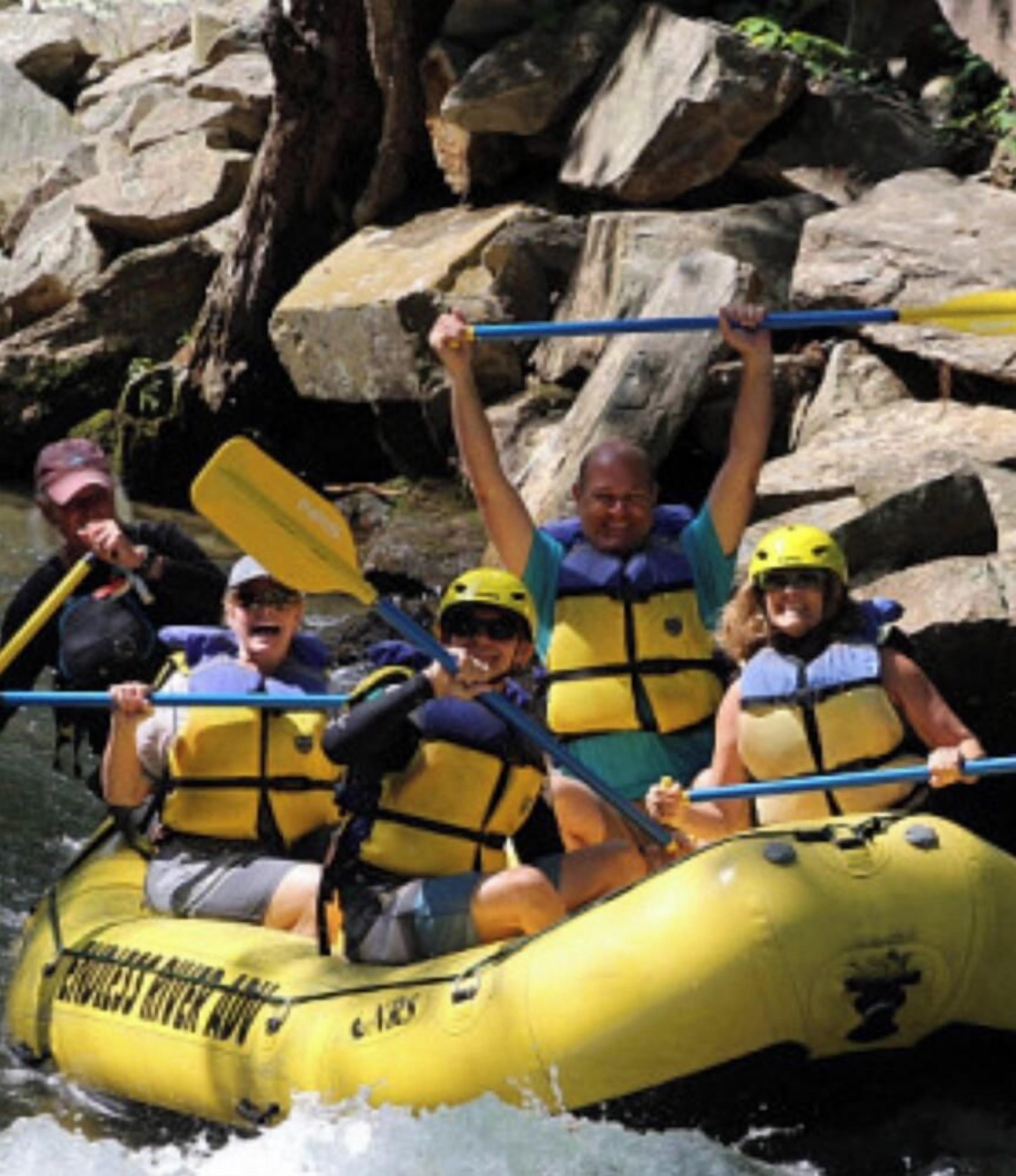 A group of people in a yellow inflatable raft on a river.