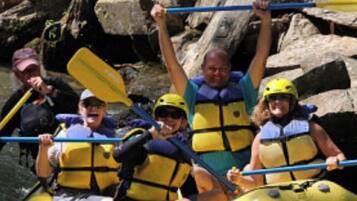 A group of people in a yellow inflatable raft on a river.