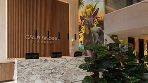A reception desk with a marble top, wooden paneling, and a large mural of a dog. - Casa Andina Standard Benavides (Lima)