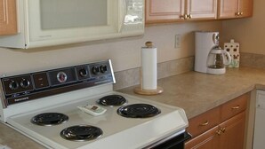 Une cuisine avec un four Kenmore blanc, un four à micro-ondes et des armoires en bois.