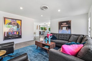 A modern living room with a sofa, coffee table, and artwork on the walls.