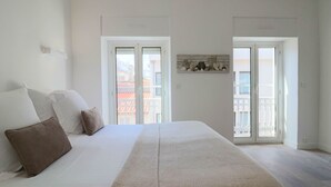A bedroom with a large bed, white walls, and a balcony with a railing. - Apt luxe 1min Palais Festivals (Cannes)