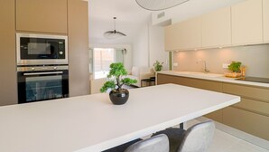 A modern kitchen with a central island, built-in oven, and a hanging light fixture. - Rooftop design apartment Cannes (Cannes)