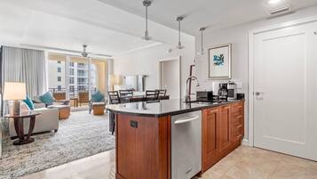 A modern kitchen with a central island, wooden cabinets, and stainless steel appliances.