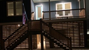 Une maison à deux étages avec un escalier en bois menant à un balcon.