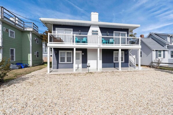 Une maison à deux étages avec un porche couvert et un petit balcon.