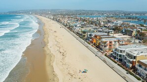 A coastal residential area with beachfront properties, a sandy beach, and a clear view of the ocean. - Ocean Front Beach Get Away w/ AC! (San Diego)