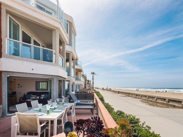 Un hôtel en bord de mer doté d’une terrasse pour prendre les repas en plein air, offrant une vue sur la plage et un balcon donnant sur l’océan.