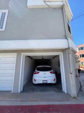 Une voiture blanche est garée à l’intérieur d’un garage.