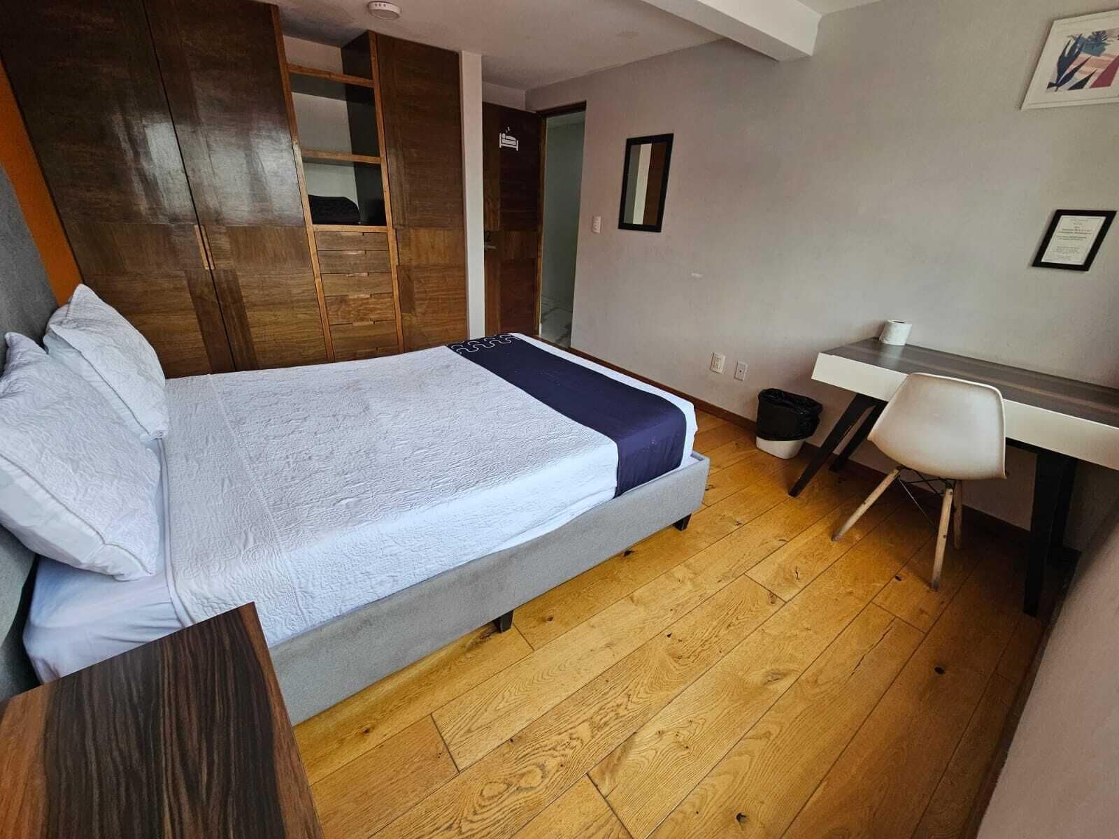 Ein Schlafzimmer mit einem Bett, einem Schreibtisch und einem Stuhl.