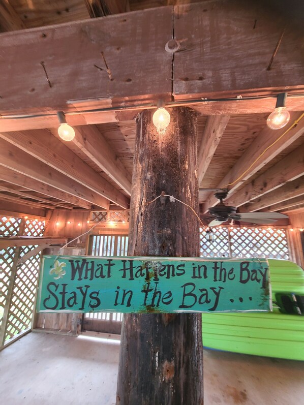 A wooden post with a sign that reads "What Happens in the Bay Stays in the Bay...".