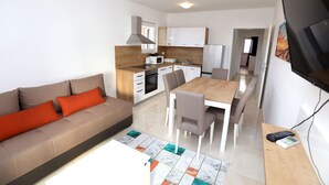 Ein modernes Wohnzimmer mit einer Couch, einem Couchtisch und einem Essbereich mit Stühlen und einem Tisch.