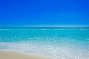 Ein Strand mit klarem türkisblauem Wasser und einem Sandufer.
