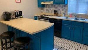 A kitchen with blue cabinets, a white countertop, a stove, a dishwasher, and a sink. - Historic Gem / Steps to Main St. & Mississippi River / 3-Season Room (Savanna)