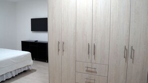 A bedroom with a bed, a wardrobe, and a TV on the wall. - Family Apt with Fast internet near park Carolina (Quito)