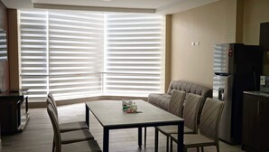 A modern living room with a dining table, sofa, and a refrigerator. - Family Apt with Fast internet near park Carolina (Quito)