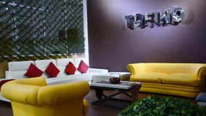 A living room with a white sofa, yellow armchairs, and a red and white patterned throw. - Family Apt with Fast internet near park Carolina (Quito)