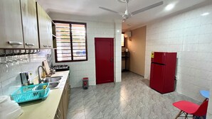A kitchen with a gas stove, sink, and a red refrigerator. - Hidden Gem In Oyibi New 2 Luxury Bedroom Apartment (Oyibi)