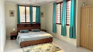 A bedroom with a bed, nightstands, a wooden wardrobe, and a ceiling fan. - Hidden Gem In Oyibi New 2 Luxury Bedroom Apartment (Oyibi)