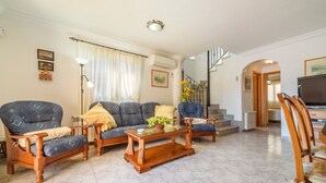 Una sala de estar con un sofá, una mesa de centro y un televisor.