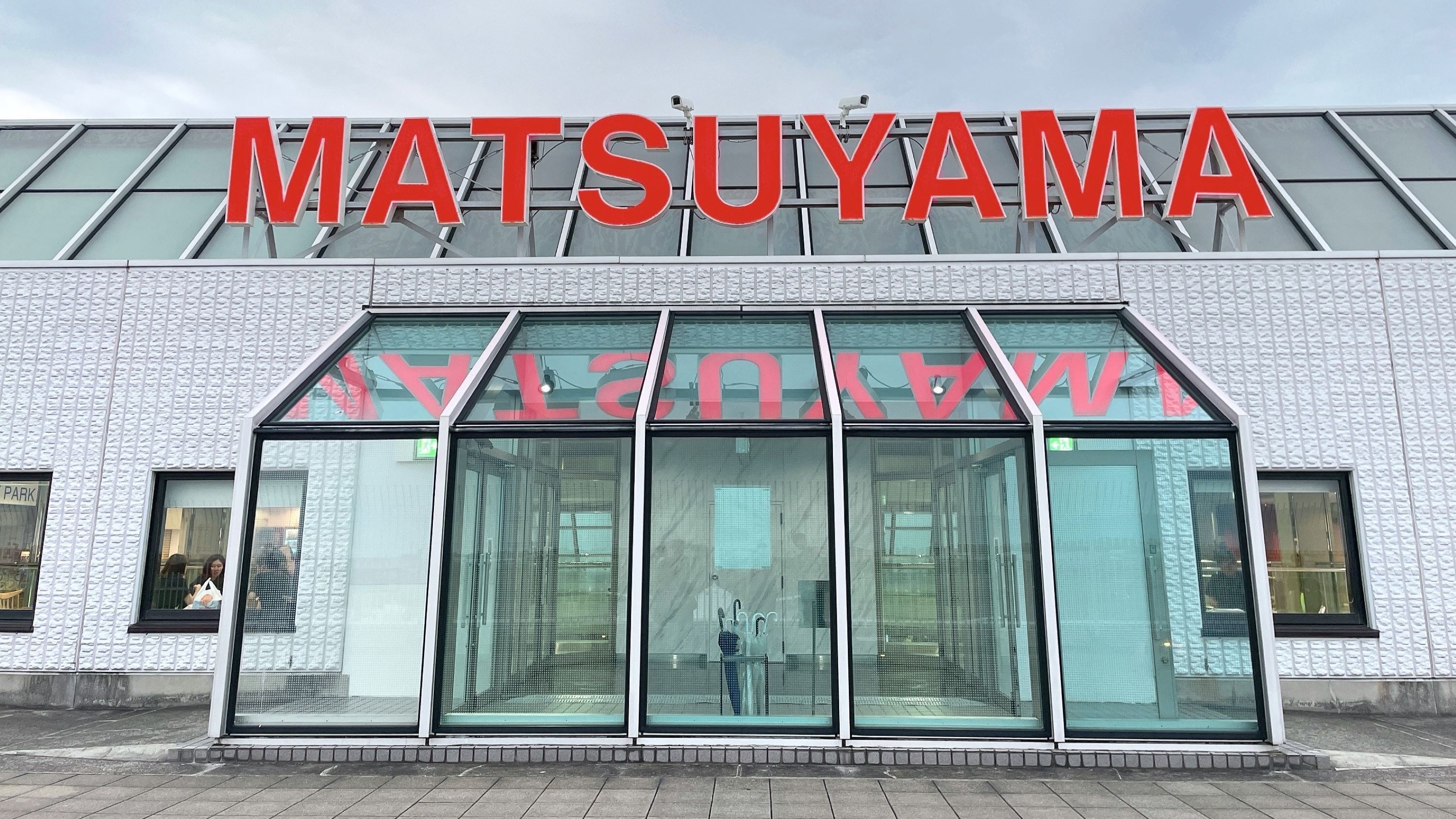 A building with a large sign reading "MATSUYAMA".