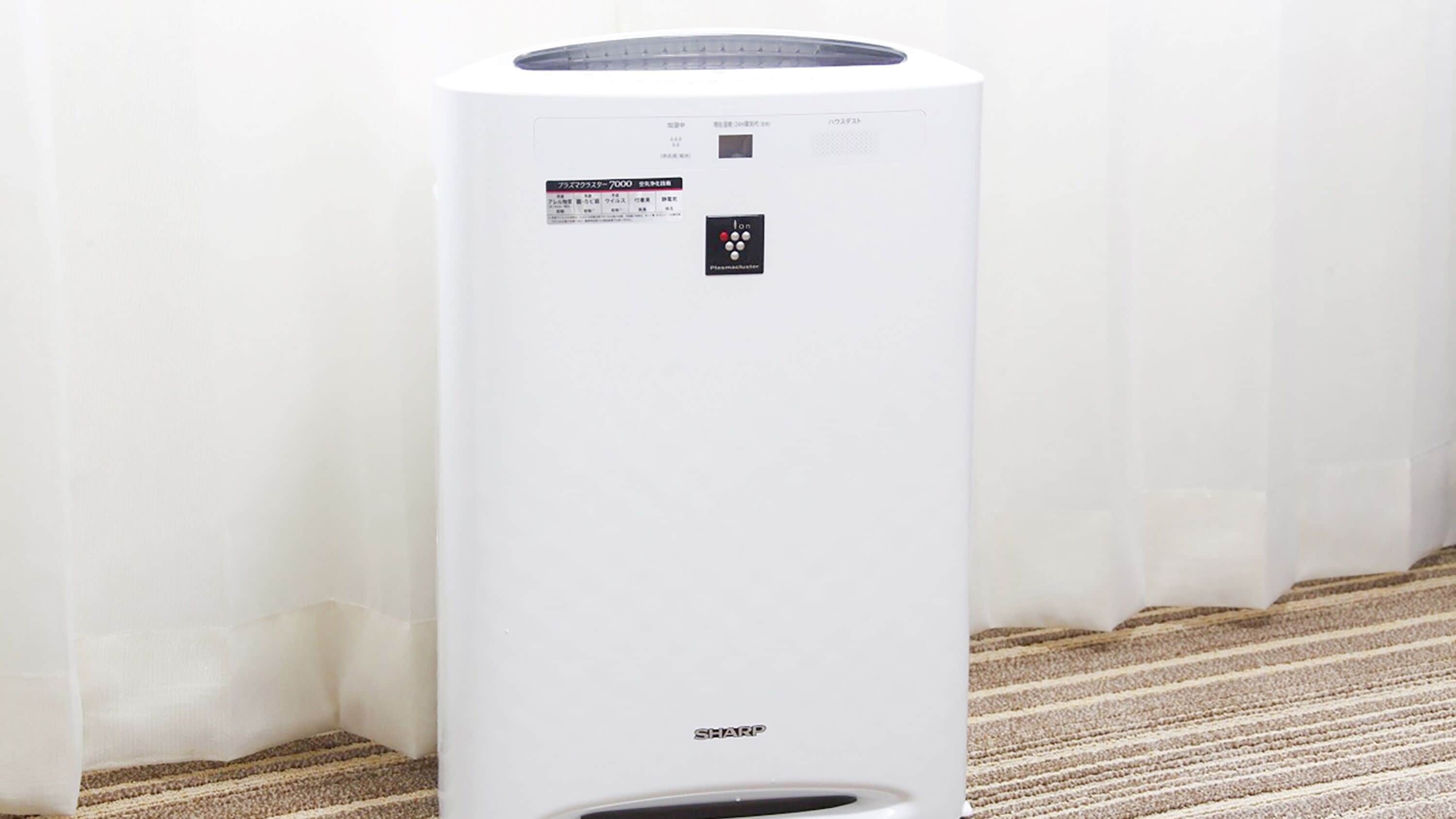 Een witte airconditioning met een bedieningspaneel en de merknaam 'SHARP' onderaan.
